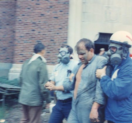 AG_cops w gas masks escort man